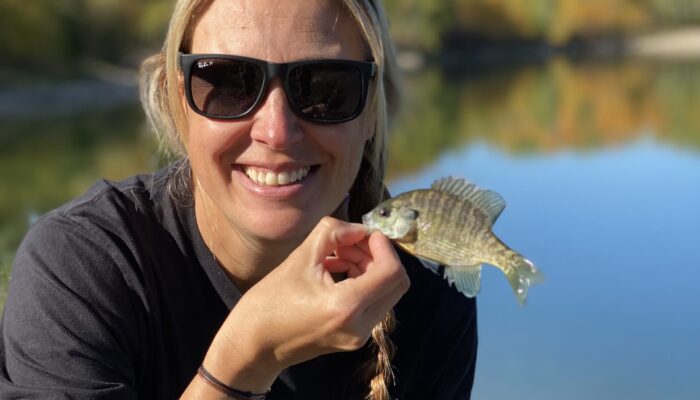 Nicole holds up a small Bluegill fish